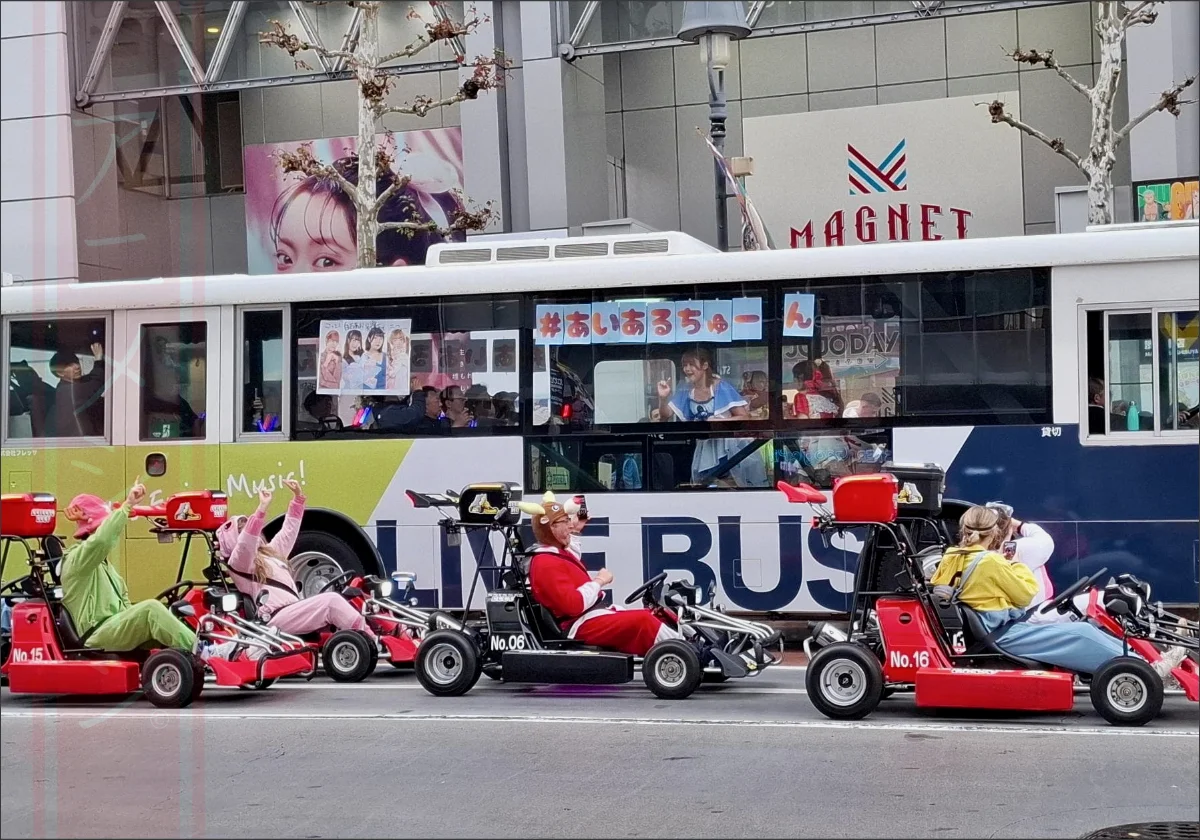Foto: Japanische Girlband spielt in einem Bus, der über die Shibuya-Kreuzung fährt – kleines Live-Konzert für ausgewählte Gäste, mitten in Tokio