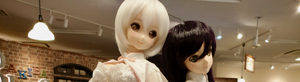 zwei Puppen mit echtem Haar lehnen aneinander