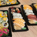 Sushi in schwarze Boxen auf einem Tisch