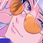 Das Bild zeigt ein junger Mann, der seine Sonnenbrille ganz leicht hervorhebt. Er schaut in Richtung des Betrachters und lächelt.